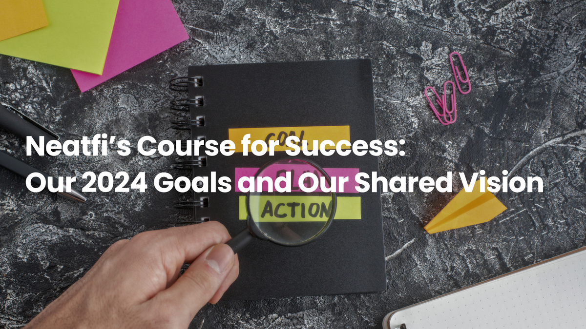 Notebook with colorful goal-setting labels, magnifying glass, sticky notes, and office supplies, representing Neatfi’s 2024 goals, action plans, and shared vision for success.