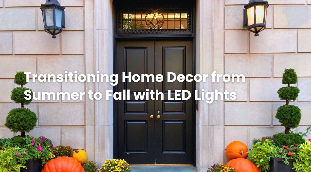 Elegant front entrance with black double doors, warm wall lanterns, pumpkins, and fall plants, showing how LED lights can transition home decor from summer to autumn.