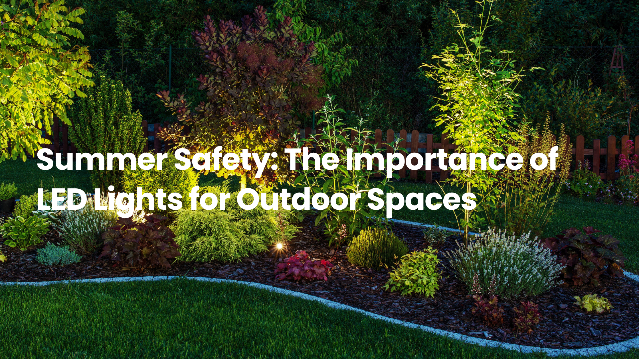 Landscaped outdoor garden at night with LED uplights illuminating trees, shrubs, and flower beds, highlighting the safety benefits of outdoor LED lighting.